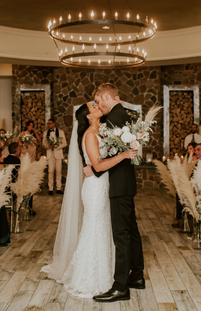 by Landmark Farmhouse wedding couple sharing kiss