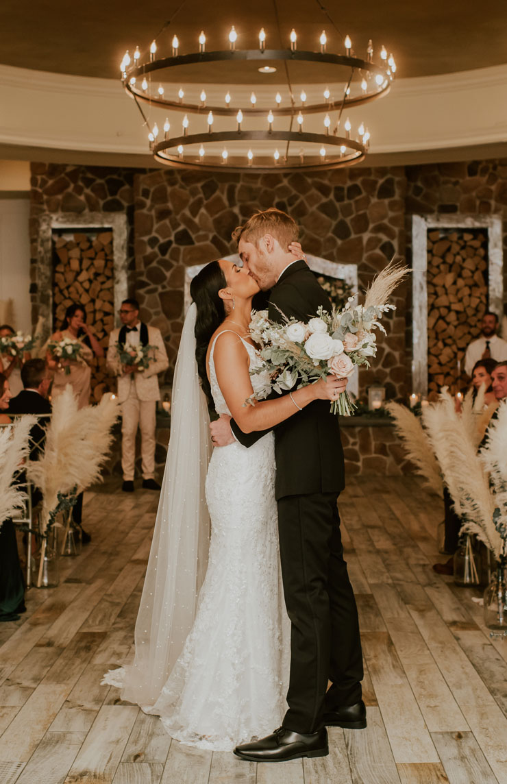 by Landmark Farmhouse wedding couple sharing kiss