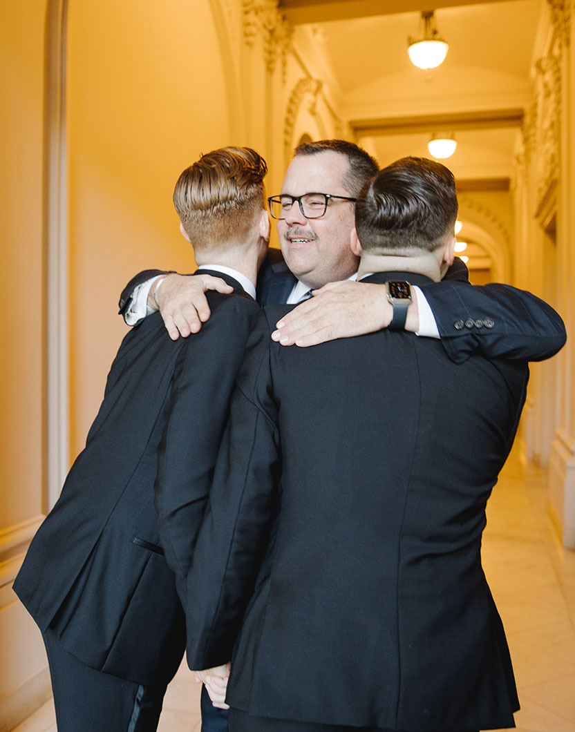 Group of men hugging at wedding event